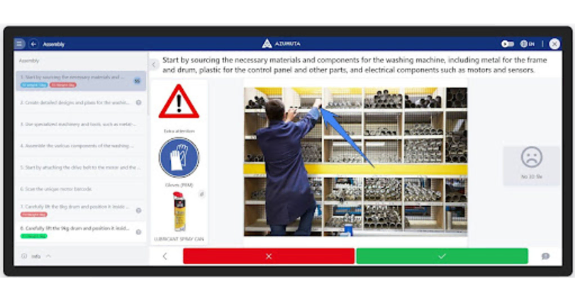 A person in blue work attire is assembling parts in a warehouse. The screen displays instructions for washing machine assembly, warning symbols, and a progress checklist. Shelves filled with metal components are in the background. Control buttons are at the bottom.