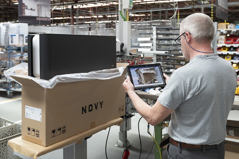 A man inspects a boxed electronic device labeled 