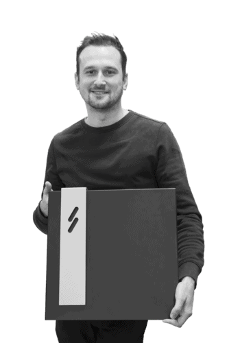 Blitzpower's CEO Alexander Hertens posing for the camera while holding a charging station.