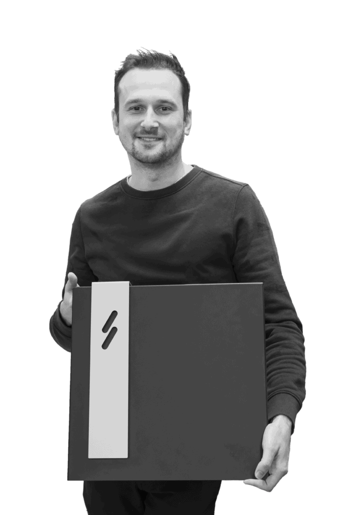 Blitzpower's CEO Alexander Hertens posing for the camera while holding a charging station.