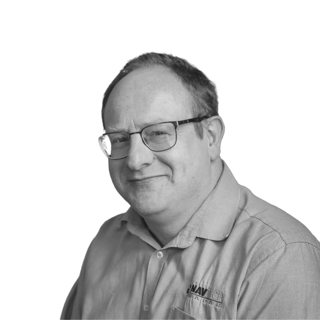 A black-and-white portrait of a man wearing glasses and a collared shirt with the NavTech Radar logo. He is smiling slightly and looking towards the camera. The background is plain white, giving the image a clean and professional appearance.